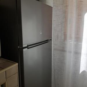 a refrigerator in a kitchen next to a curtain at VINTAGE HOME in Sassari