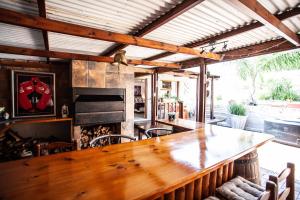 a large wooden table in a room with a fireplace at Flametree Guesthouse in Swellendam