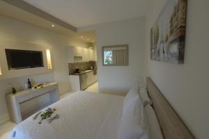 biała sypialnia z dużym łóżkiem i łazienką w obiekcie Stefanos Resort w mieście Mesongi