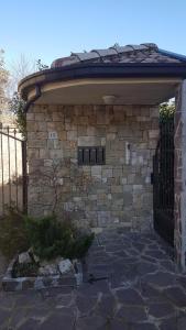 a stone building with a gate and a fence at ILLUVIA affitto camere in Cornaredo