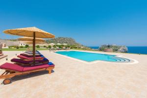 ファリラキにあるBlack Diamond Villa Pasithea in Rhodes Greeceのスイミングプールの隣の椅子とパラソルのグループ