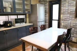 a kitchen with a table and chairs and a refrigerator at ウインザー宇佐美 in Ito