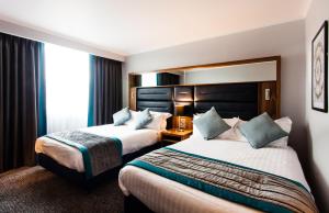 a hotel room with two beds and a window at Crowne Plaza Leeds, an IHG Hotel in Leeds