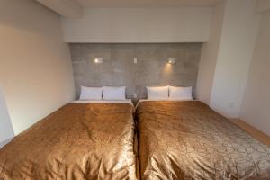 ein Schlafzimmer mit einem großen Bett mit zwei Kissen in der Unterkunft MK Hotels Nishinakasu in Fukuoka