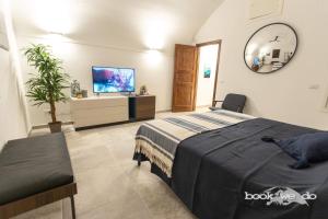 - une chambre avec un lit et une télévision à écran plat dans l'établissement La Rocca 2 - Bookwedo, à Porto Ercole