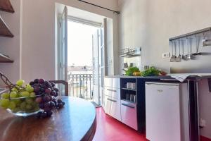 uma cozinha com uma mesa com uma taça de uvas em Domus Mazzini em Turim