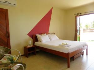- une chambre dotée d'un lit avec un mur rouge dans l'établissement Red House Pousada, à Flecheiras