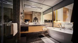 
a bathroom with a tub, sink, toilet and bathtub at EQ Kuala Lumpur in Kuala Lumpur
