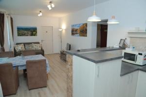 a kitchen and living room with a table and a microwave at Casa Tinkerbell in Sovata