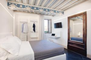 a bedroom with a bed and a mirror and a window at B&B il Barbero in Siena