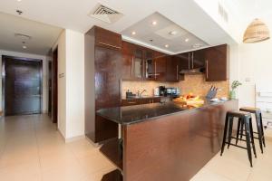 a kitchen with wooden cabinets and a counter top at Quintessential Quarters - Gorgeous Sunset View in the Heart of Downtown in Dubai