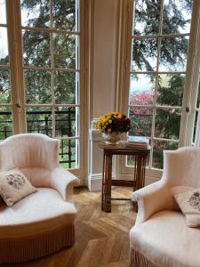 une chambre avec deux chaises et une table avec fenêtres dans l'établissement La Villa by Michel Gonet, à Épernay