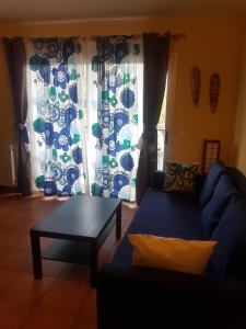 a living room with a blue couch and a table at Casa Beatriz in Cala San Vicente