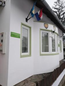 a white house with windows and flags on it at Casa Tinkerbell in Sovata