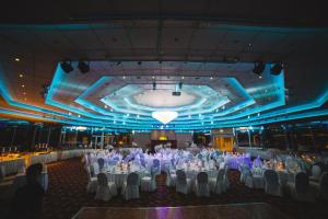 a large banquet hall with white tables and chairs at St Raphael Resort in Limassol +37 photos