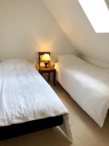 a bedroom with two beds and a lamp on a table at Torvet 19 - Maribo in Maribo