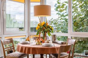 a dining room with a table with flowers on it at Ferienwohnung Marianne in Radolfzell am Bodensee