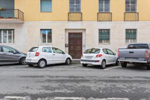 three cars parked in a parking lot in front of a building at Marradi Apartment with Balcony in Livorno