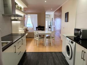uma cozinha com uma mesa e uma cozinha com uma sala de jantar em Casa Claudia - Pool and Wifi em Silves