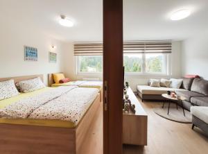 a bedroom with a bed and a living room at Apartmani Jahorina Olimpijska kuca in Jahorina