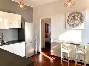 Una cocina con gabinetes blancos y un refrigerador blanco. en Fontana Di Trevi Luxury Apartments, en Roma