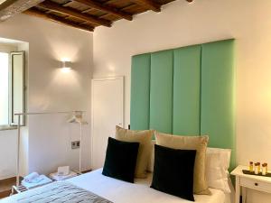 Un dormitorio con una pared verde y una cama con almohadas en Fontana Di Trevi Luxury Apartments, en Roma