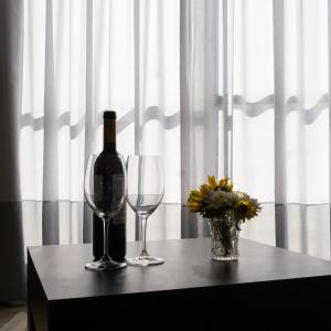 a bottle of wine and two glasses on a table at Kfar Maccabiah Business & Sport Hotel in Ramat Gan