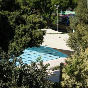 an overhead view of a swimming pool with trees at Kfar Maccabiah Business & Sport Hotel in Ramat Gan