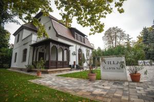 a white house with a sign in front of it at Villa Campana in Siófok