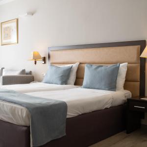 two beds in a hotel room with two pillows at Kfar Maccabiah Business & Sport Hotel in Ramat Gan