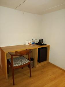 a wooden desk with a chair next to a table at Native INN By Heda Hospitality in Belgaum