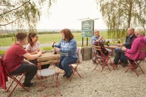 a group of people sitting at a table with drinks at Hotel Weimarer Berg in Apolda