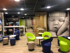 a restaurant with green and blue tables and chairs at Ibis Budget Lyon Caluire Cité Internationale in Caluire-et-Cuire