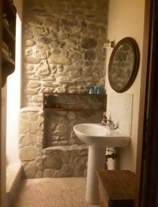 ein Badezimmer mit einem Waschbecken und einer Steinmauer in der Unterkunft All'Ovile in Montevescovo