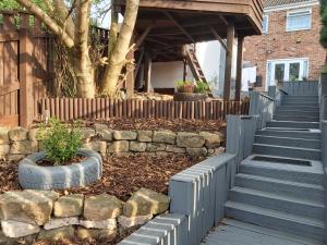 a retaining wall and stairs in a yard with a tree at Bakewell House - Huku Kwetu Notts -Spacious 3 Bedroom House - Suitable & Affordable Group Accommodation - Business Travellers in Nottingham