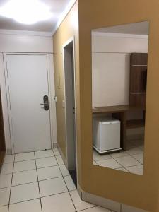 a room with a door and a kitchen with a microwave at Via Caldas Exclusive in Caldas Novas