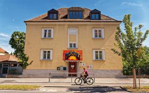 una persona montando una bicicleta delante de un edificio en Radfahrerherberge Krems en Krems an der Donau