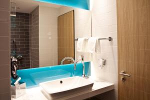 ein Badezimmer mit Waschbecken und Spiegel in der Unterkunft Holiday Inn Express Oberhausen by IHG in Oberhausen + 47 Fotos