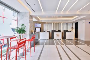 Hotel Midcity Myeongdong في سول: لوبي المكتب والكراسي الحمراء والطاولات