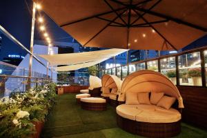 a patio with couches and umbrellas on a building at Hotel Midcity Myeongdong in Seoul