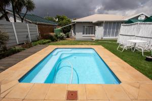 a swimming pool in the yard of a house at WILLOW GUEST HOUSE in Boksburg