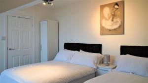ein Schlafzimmer mit 2 Betten und einem Bild an der Wand in der Unterkunft Copperfield House in Leeds