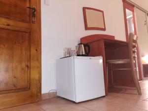 a white refrigerator in a room with a wooden door at Penzión Rudolf in Prievidza