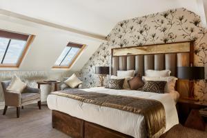a bedroom with a large bed and a chair at Grosvenor Pulford Hotel & Spa in Pulford