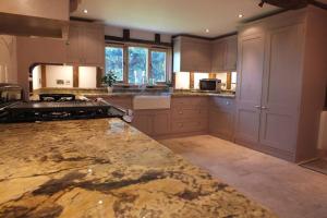 a large kitchen with a marble counter top at Old Oak Barn - Beautiful barn conversion with wonderful Jacuzzi hot tub in Stowmarket