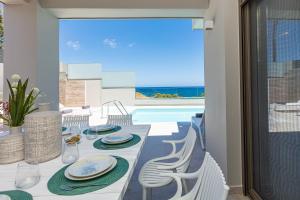 een eetkamer met een tafel en uitzicht op de oceaan bij Lagoon Seaside Villa, Sumptuous Retreat,By ThinkVilla in Panormos Rethymno