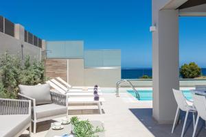 patio con sedie e piscina di Lagoon Seaside Villa, Sumptuous Retreat,By ThinkVilla a Panormos