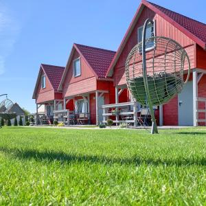 a house with a basket in the grass in front of it at Domki na Miłej in Niechorze