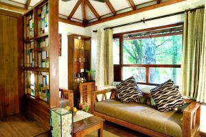 a living room with a couch and a window at Vythiri Resort in Vythiri