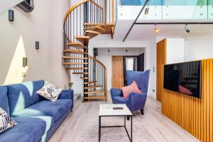 a living room with blue couches and a staircase at Odrzańska Residence Old Town in Wrocław